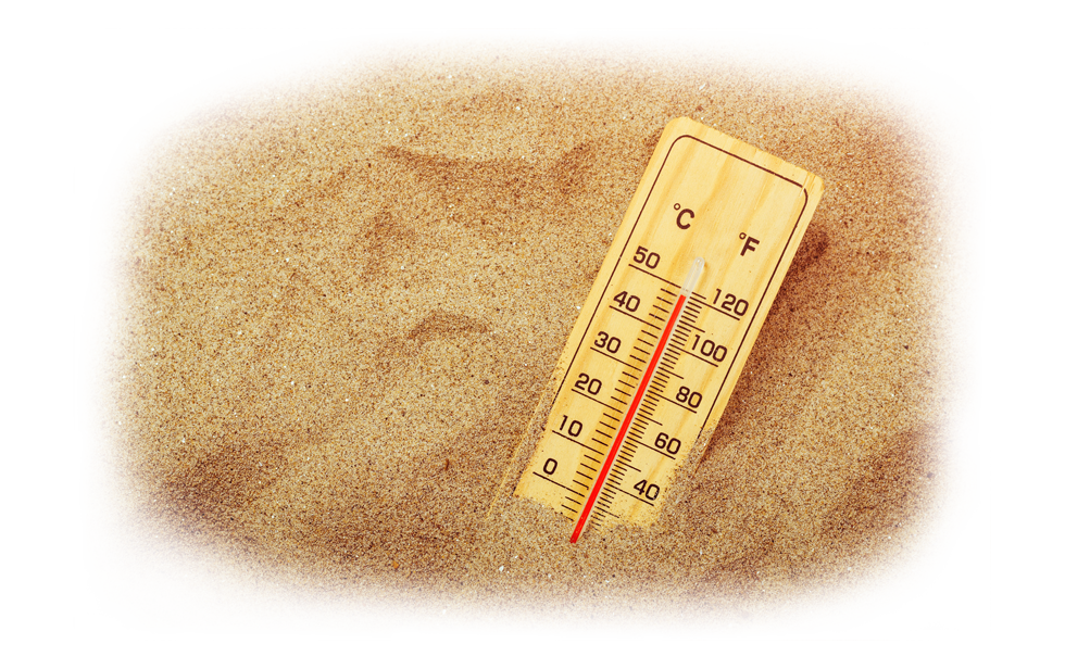 Thermometer in warm sand showing high temperature.